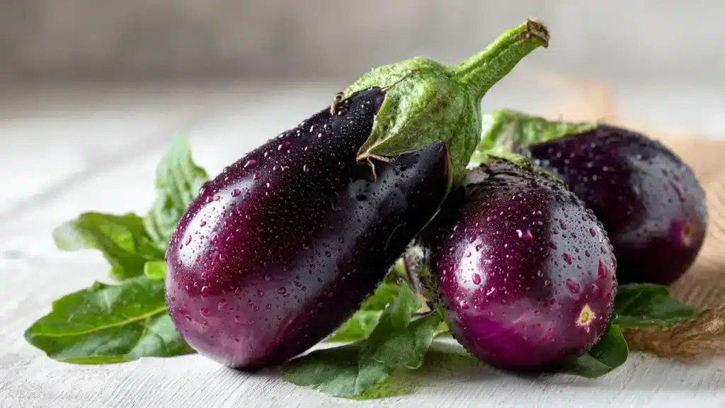 Fresh aubergines on kitchen table